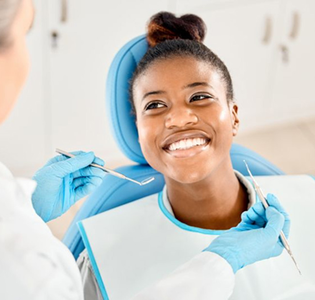 Dental patient smiling up at her care provider