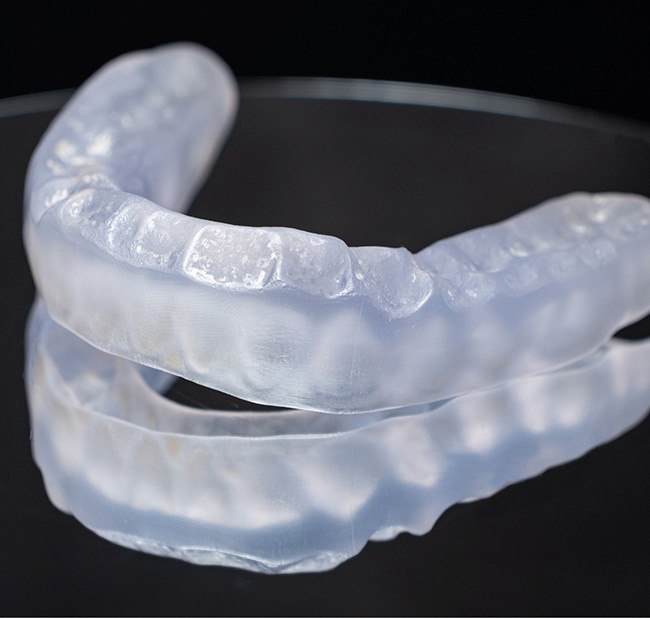 Close-up of nightguard for bruxism on reflective surface