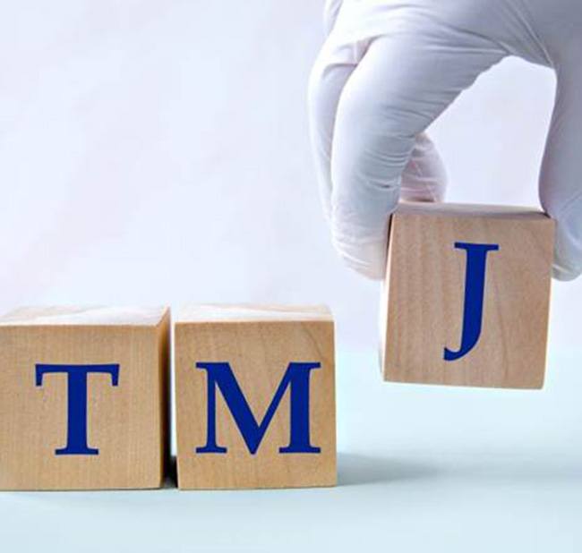Three wooden blocks that read TMJ