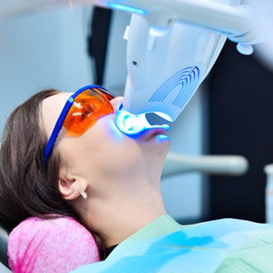 Woman undergoing in-office teeth whitening treatment