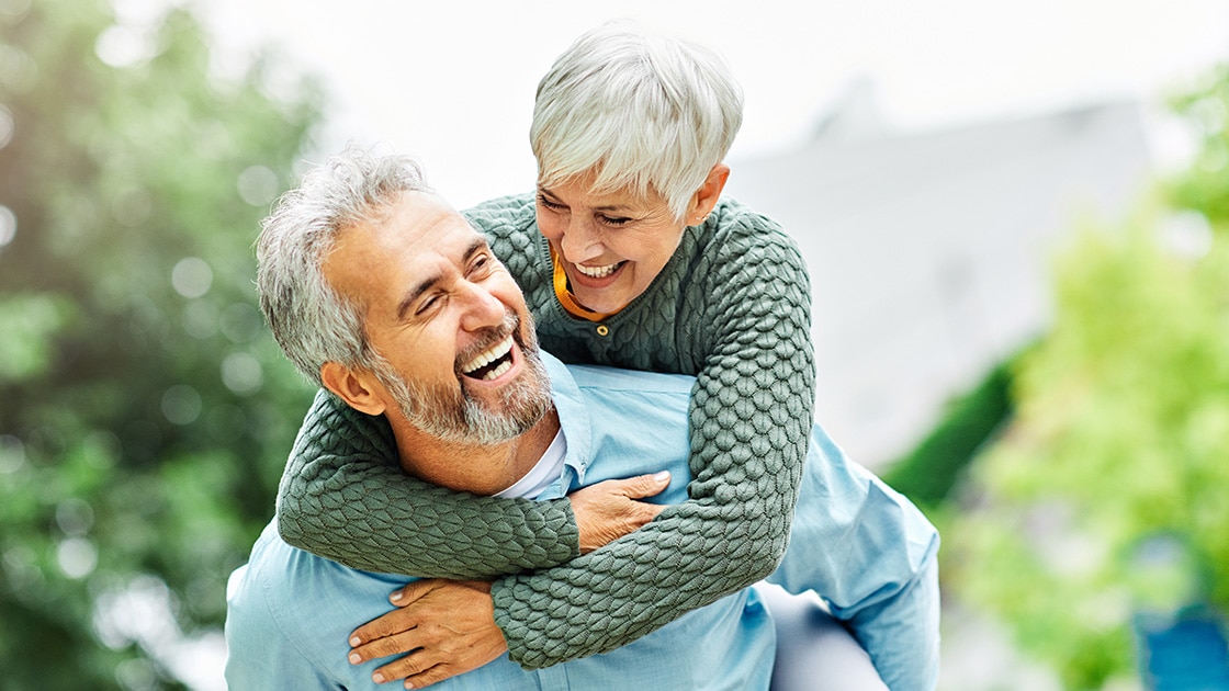 Smiling Couple In Front Of Trees - Periodontal Procedures